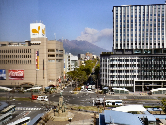 Sakurajima showering the city with ash, as viewed from Kagoshima-chuo Station